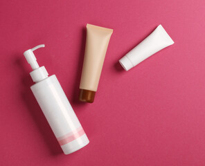 White cream tube and lotion dispenser bottle, Foundation on pink background