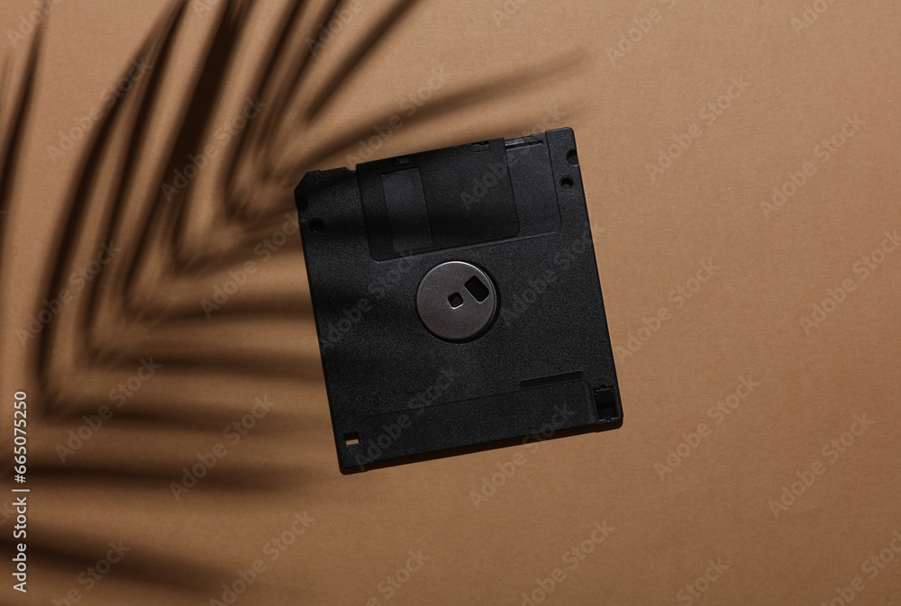 Poster retro 80s floppy disk on brown background with palm leaf shadow. creative layout