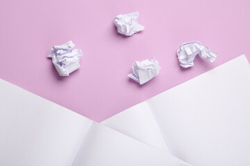 Crumpled paper balls with open notebboks on pastel background. Education, Business concept