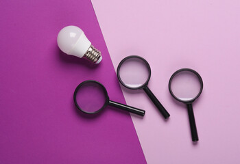 Magnifier with a light bulb on a magenta background. Creative Idea