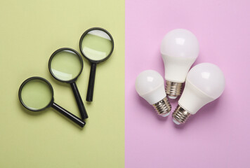 Magnifiers with light bulb on a green purple background. Business concept