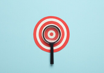 Magnifier with a target on a blue background. Target search, business concept