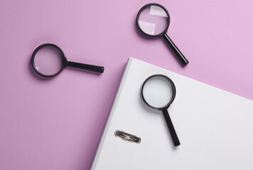 Magnifiers with folder on magenta background