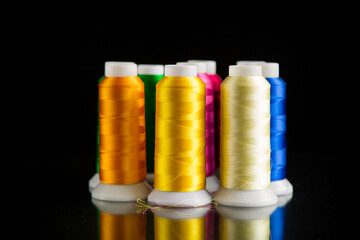 set of different color sewing threads,on black background.