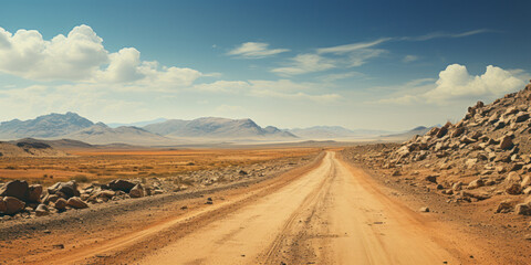 Fototapeta na wymiar An empty dirt road leading to the mountains