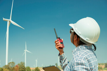 Female engineers communicate with the work team by walkie-talkie to maintain or operate Wind...