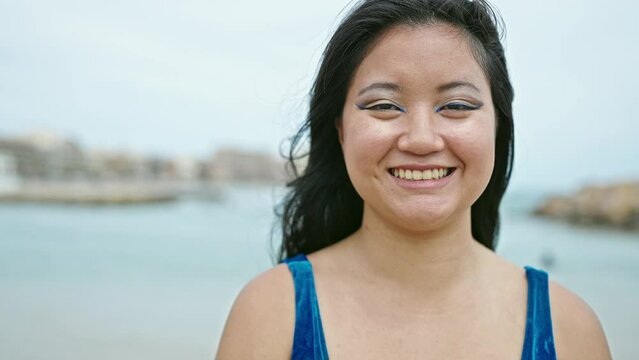 Young chinese woman tourist smiling confident wearing bikini at the beach