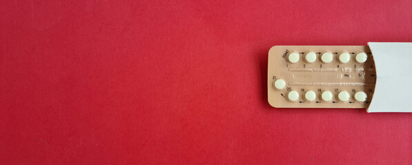  Blister packs of contraceptive pills on red background