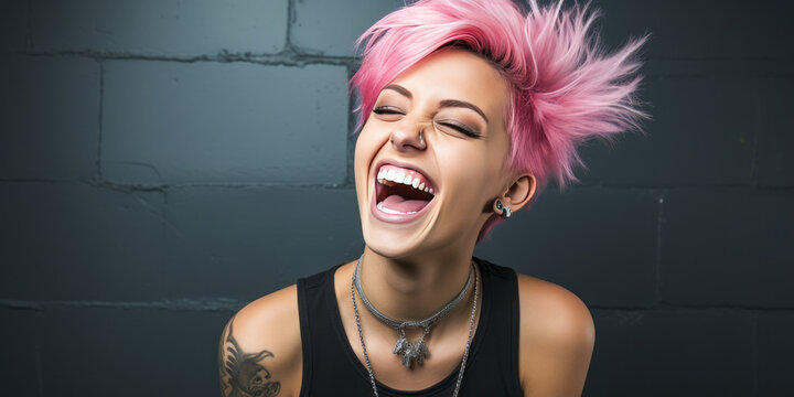 Stylish woman with pink hair and piercings laughing by black wall.
