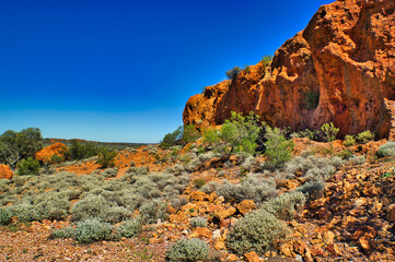 Desert scenery with red rocks and sparse vegetation in the dry outback of Western Australia. Shire...