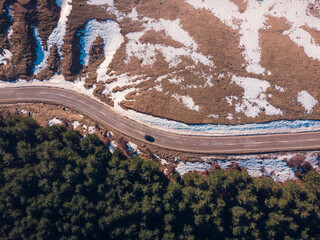Aerial view of road amidst snow and greenery