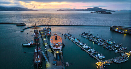Gorgeous sunset lighting over San Francisco Bay with Alcatraz and Hyde St Pier aerial