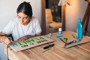 Woman painting a poster about the environment