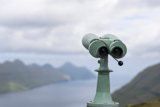 Binoculars of green coast against ocean