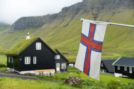 National flag hanging against houses and mountain