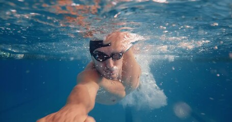 Underwater Shot: Fit Muscular Swimmer doing Laps in Swimming Pool. Handsome Professional Athlete swims at Great Speed- Ready To Set World Championship Record. Stylish Tracking Shot