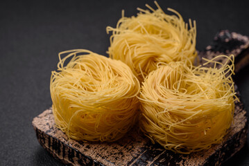 Raw capellini pasta or noodles with salt and spices