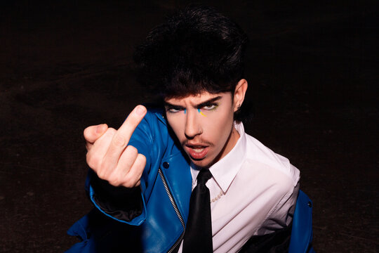 Title: Rebellious man with colorful makeup gesturing defiantly
