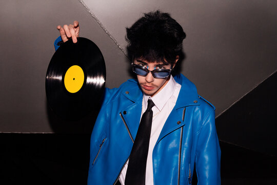 Retro-styled man with vinyl record in the dark