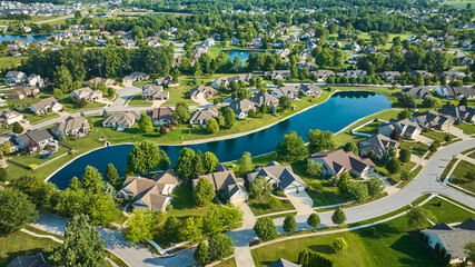 Aerial over neighborhoods on bright sunny day with multiple ponds