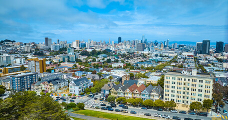 Aerial San Francisco The Painted Ladies with wide view of city and skyscrapers under pretty sky