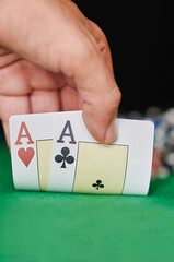 Closeup of hand with pair of aces in poker