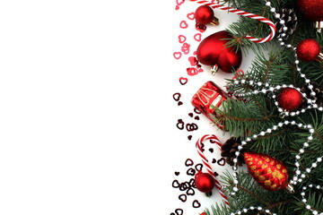 Christmas tree toys and spruce branches lie on a white background.