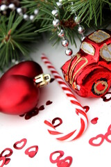  Christmas tree toys, a branch and a candy cane lie on a white background.