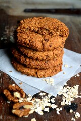 Home made oat cookies, piled high in a stack and displayed on baking paper.