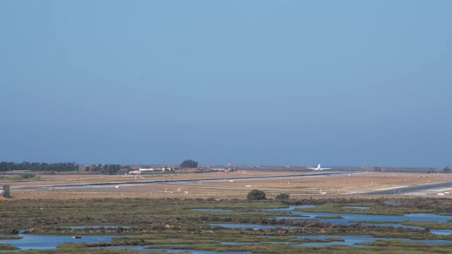 A commercial airliner takes off from Faro Airport, Portugal. Overlooking the Ria Formosa Natural Park