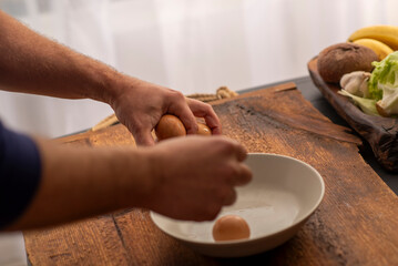 Fototapeta na wymiar boiled eggs in male hands over the kitchen table