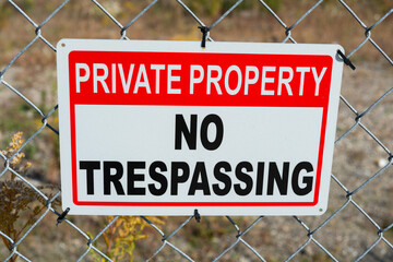private property no trespassing sign tied to a metal fence - obrazy, fototapety, plakaty
