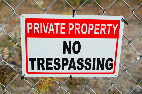 private property no trespassing sign tied to a metal fence