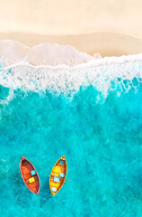 Fototapeta premium Aerial View of Sandy Tropical Beach and Ocean with Red and Yellow Boats Floating on Turquoise Water. Summer Poster Background.