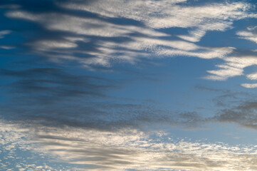 Obraz premium Background of a blue sky with beautiful cirrus clouds at sunset