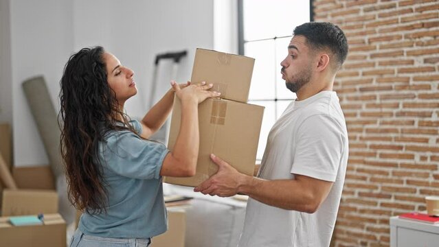 Man and woman couple holding packages at new home