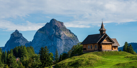 Fototapeta na wymiar View of an old wooden church in the Swiss mountains on Lake Lucerne.