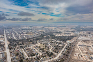 Obraz premium : Aerial view of Barrie, Ontario, showcasing a frozen Lake Simcoe on a cloudy day. Residential areas line the icy lake, reflecting the serene winter landscape of Canada.