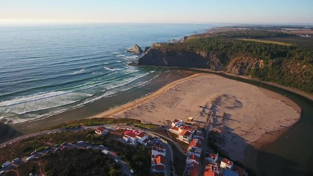 Aerial video filming by drone of the sea bay and beach near the village of Odeceixe Alentejo Portugal. During sunset, moving in a circle