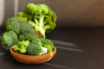 Fresh green broccoli in brown wooden bowl.