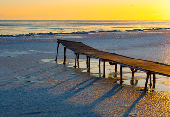 frozen pontoon on the lake in winter at sunrise