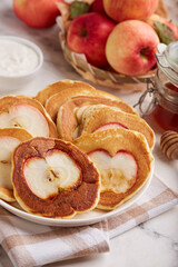 Naklejka na ściany i meble Pancakes with apples, served with sour cream and honey. Healthy breakfast for the family. 