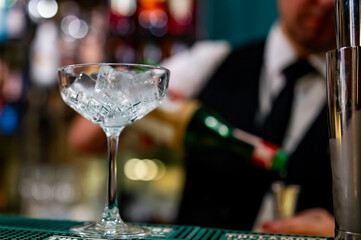 Ice cube in an empty glass on a bar counter in bar or pub