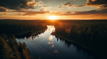 Aerial view of sundown over a river, vibrant reflection on water, meandering through a forest