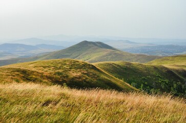 Fototapeta premium AI generated illustration of a grassy hillside overlooking the distant mountain range