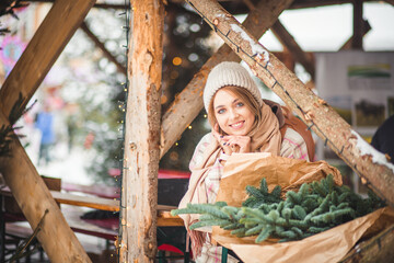 A girl in a wooden tent decorated with garlands. Fair in the center of Europe. A smiling girl in...