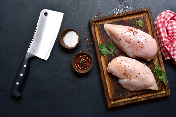 Raw organic chiken breasts with ingredients for making. Top view with copy space.