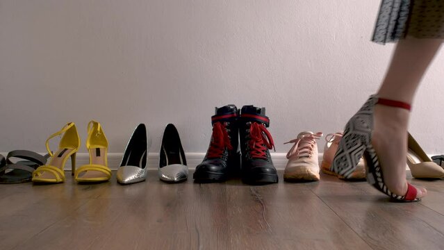 Woman chooses shoes from wardrobe