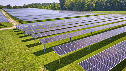 Horizontal rows of solar panels on farm on sunny summer day in Midwest aerial