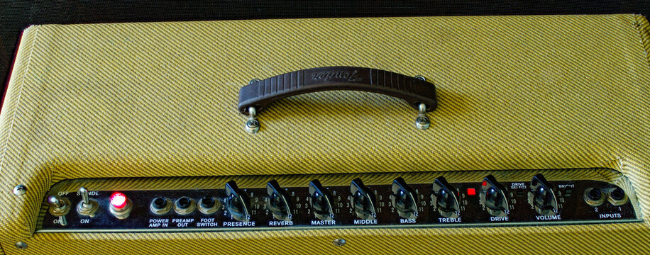 Old vintage retro style guitar tube amp or amplifier yellow tweed design Isolated on dark background. Control panel Volume , treble, bass, tone buttons and knobs Oct 14, 2023 Florida